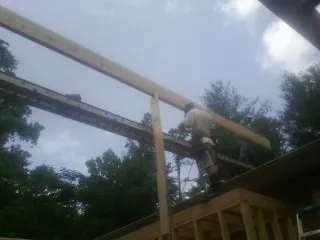 Carpenter setting a ridge beam over a new addition frame — Ice Dam Removal by Roofing Brothers in Kooskia