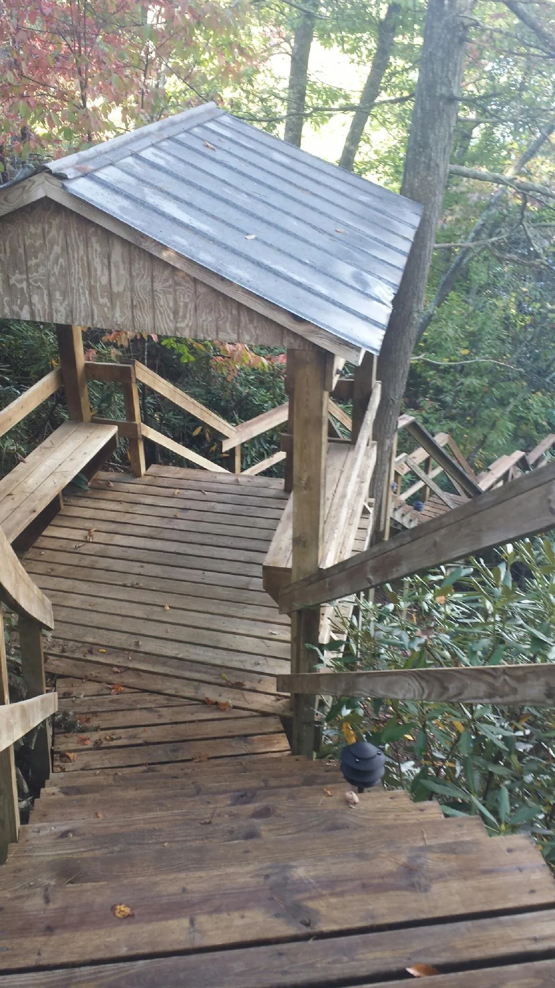 Metal roofed shelter over wooden steps on a wooded walkway — Skylight Repair & Installation work by our crew in Kooskia
